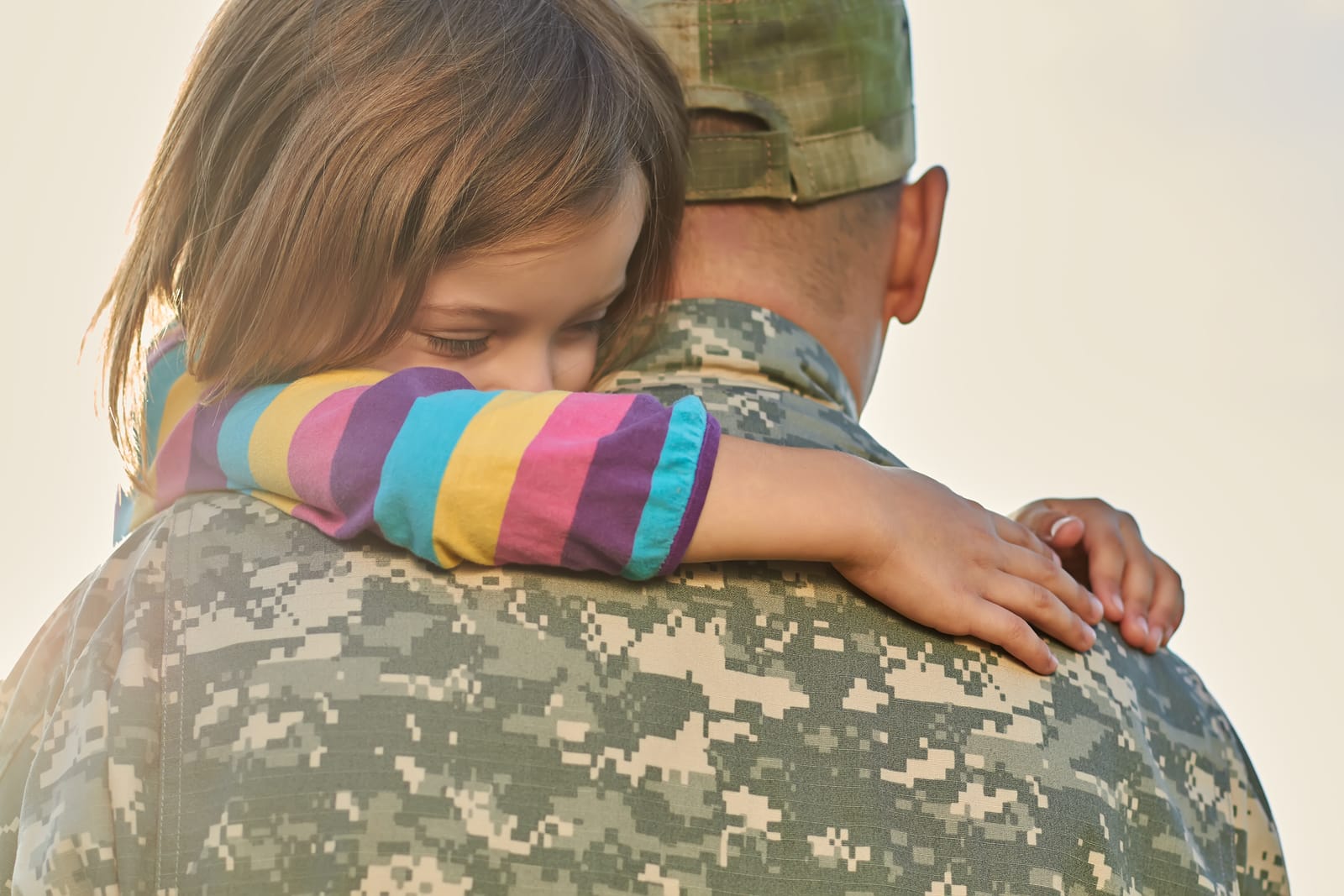 Little Female Child Is Hugging A Soldier. Close Up Portrait Of H