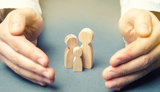 Insurance Agent Holds Hands Near The Family. The Concept Of Insu