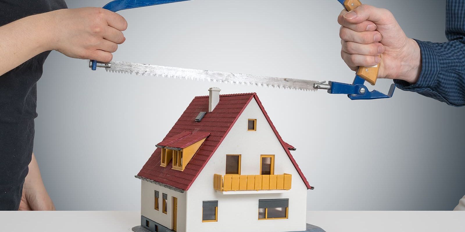 Divorce And Dividing A House Concept. Man And Woman Are Splittin