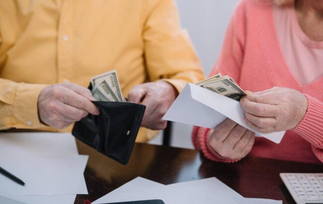 cropped-view-of-senior-couple-holding-wallet-and-e-2022-12-16-20-42-15-utc